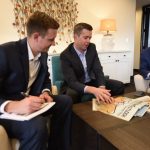 three men reading around coffee table